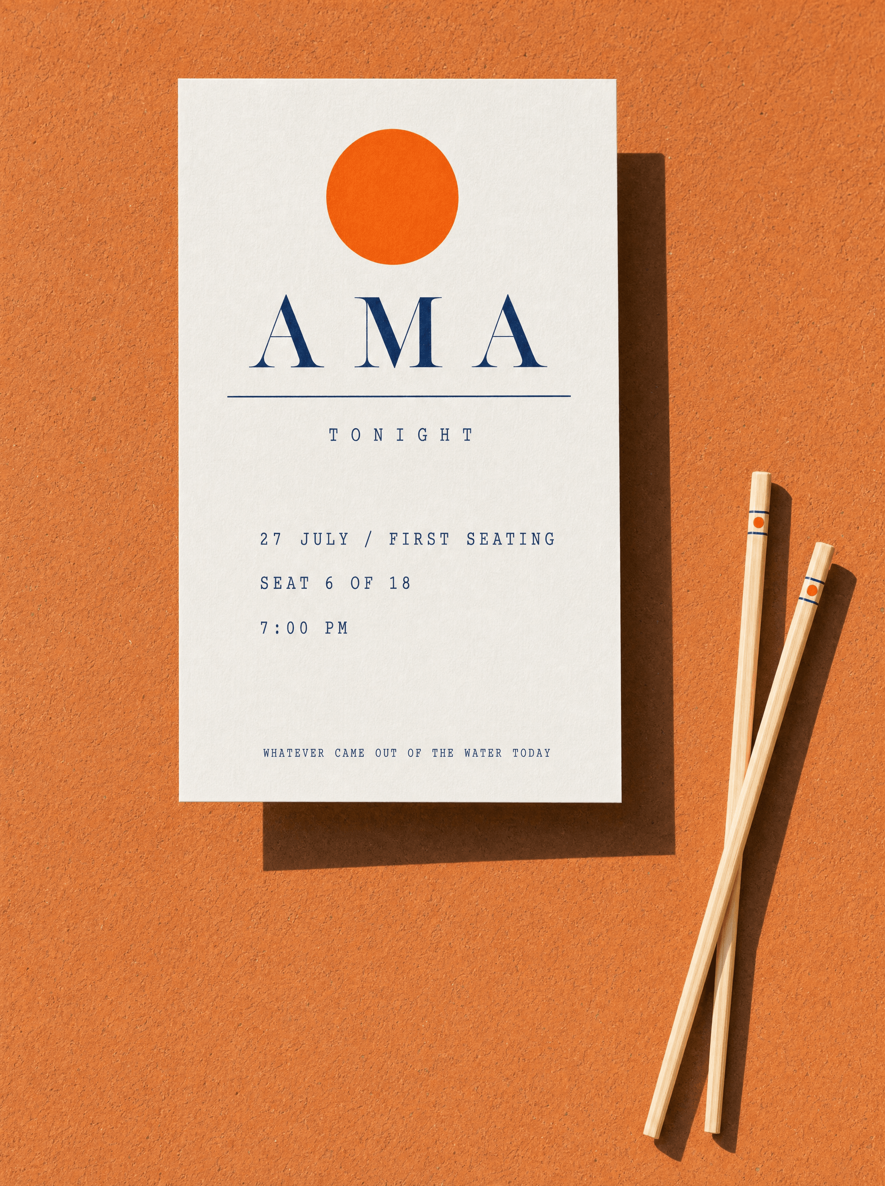 Ama placecard at a seat, with branded chopsticks alongside
